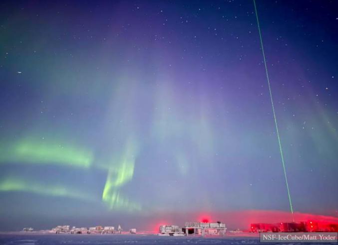 IceCube station with aurora and laser beam